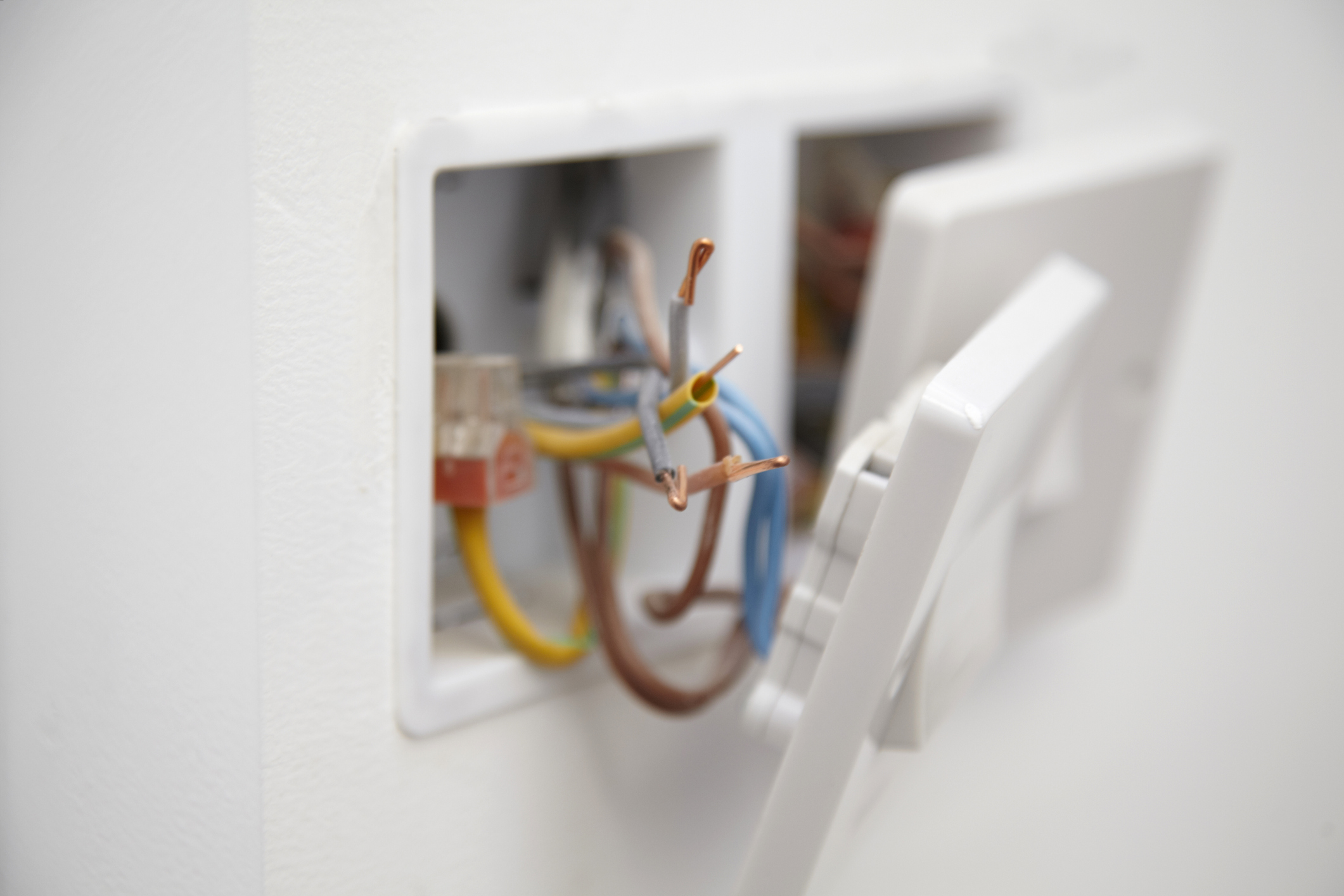 Close up of a 13 amp electrical socket being wired with exposed wires